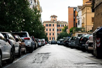 Strada urbana italiana con auto parcheggiate su entrambi i lati